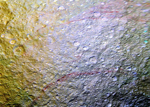 Bogenförmige rote Streifen auf der Oberfläche des Saturnmondes Tethys geben den Forschern Rätsel auf.