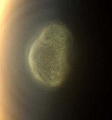 Diese 2012 erstellte Nahaufnahme zeigt die frühen Veränderungen, die sich an Titans Südpol ereigneten. Die Cassini-Kamera entdeckte diese beeindruckende Wolke, die in einer Höhe von etwa 300 Kilometern schwebt. Nun hat Cassinis Thermal Infrarot-Instrument darunter eine massive Eiswolke entdeckt.