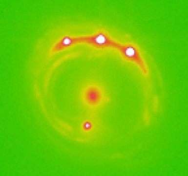 Die als Gravitationslinse wirkende Galaxie RX J1131-1231 in der Bildmitte und vier Hintergrund-Quasare. Bild: University of Oklahoma