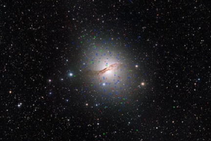 Diese riesige elliptische Galaxie NGC 5128 (bekannt als Centaurus A) ist die nächst gelegene Galaxie dieses Typs. Sie ist etwa 12 Millionen Lichtjahre entfernt. Bei Beobachtungen mit ESOs Very Large Telescope in Chile wurde um diese Galaxie eine neue Klasse von „dunklen“ Kugelsternhaufen entdeckt. Diese sind auf der Aufnahme in rot markiert. Normale Kugelsternhaufen in blau und Kugelsternhaufen, die ähnliche Eigenschaften wie Zwerggalaxien haben in grün.