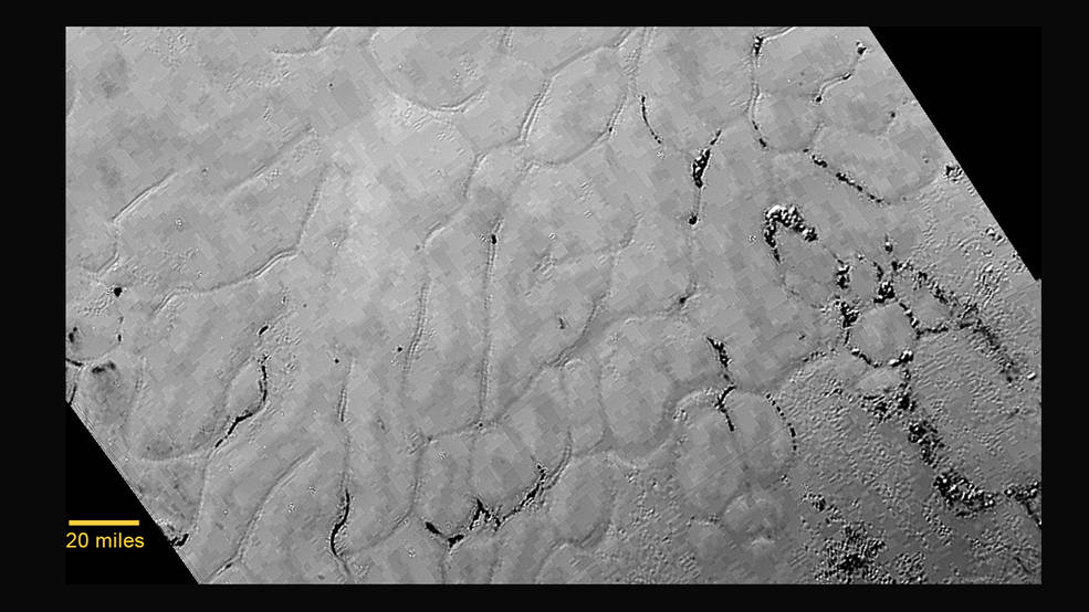 Links der Mitte von Plutos riesiger herzförmiger Region – informell auf den Namen „Tombaugh Regio“ getauft – liegt eine große, kraterlose Ebene, die vermutlich nicht älter als 100 Millionen Jahre ist und vielleicht noch heute von geologischen Prozessen geprägt wird. Die gefrorene Region liegt nördlich von den eisigen Bergen Plutos und wurde informell „Sputnik Plain“, nach dem ersten künstlichen Satelliten der Erde benannt. Die Aufnahme stammt vom 14. Juli 2015 und wurde von LORRI aus einer Entfernung von 77 000 Kilometern gemacht. Die Auflösung beträgt 1 Kilometer pro Pixel. Das blockartige Aussehen einiger Details entstand durch die Kompression des Bildes.